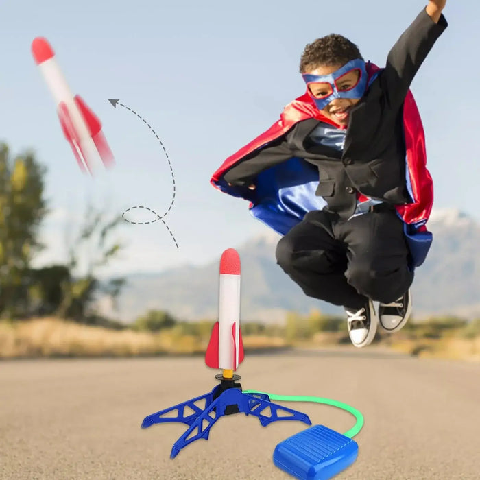 Child in superhero costume joyfully launching rockets with air-powered launcher outdoors. Fun backyard activity for kids.