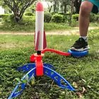 Child stomping on air-powered rocket launcher in a park, ready to launch foam rocket into the sky for outdoor fun.