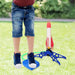 Child stomping on air-powered rocket launcher, ready to launch foam rocket in backyard adventure.