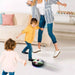 Mom and two kids playing with a glowing hover soccer ball toy indoors, enjoying active fun in a family setting.